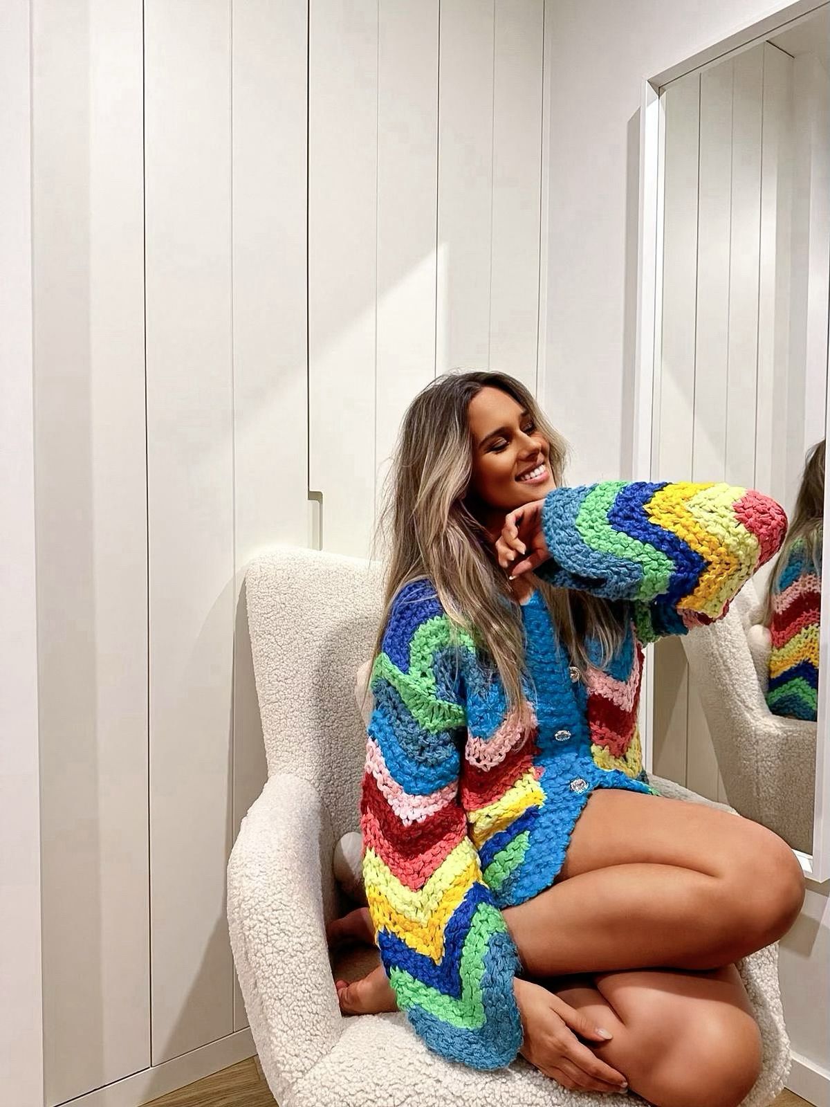 Woman wearing a colorful knitted cardigan in rainbow colors